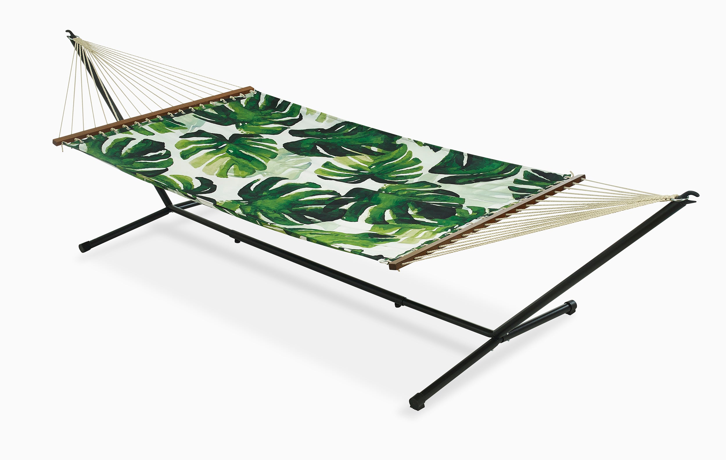 Full view of green tropical leaf hammock hung on a black metal stand
